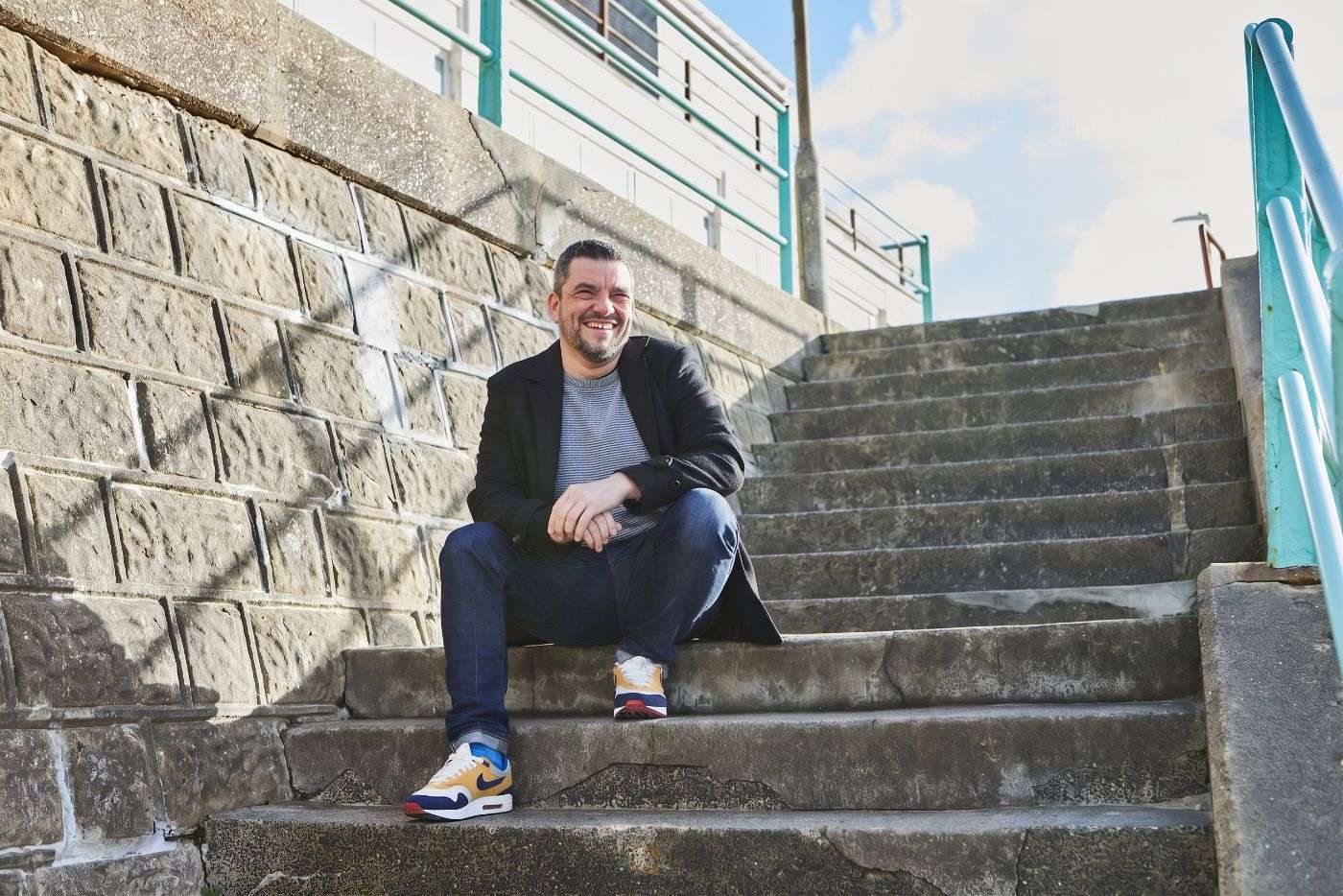 Tom laughing on the seafront steps in Saltdean